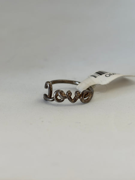 Close-up image of a sterling silver ring featuring the word “Love” in cursive script on a white background.