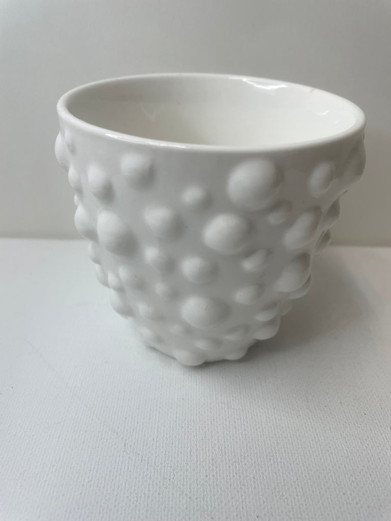 A white hobnail ceramic vase with a raised bubble texture, sitting on a white background.