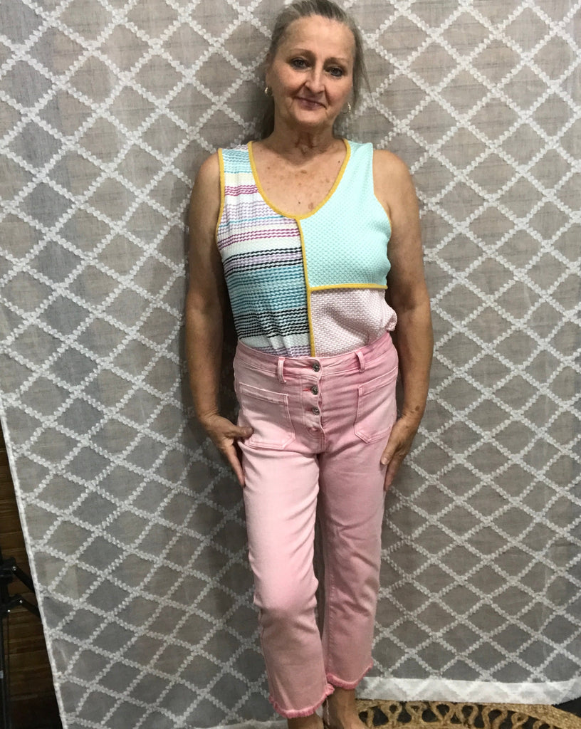 light pink jeans with multiple buttons, pockets, and frayed bottoms