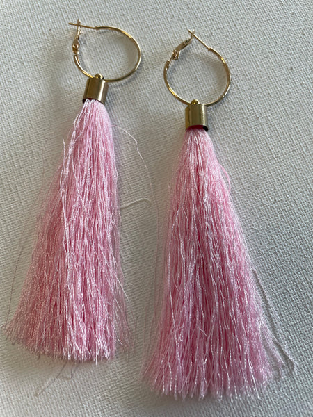 Pink tassel earrings with gold hooks on a light gray background