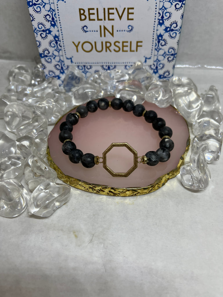 Black beaded bracelet with gold octagon in the middle