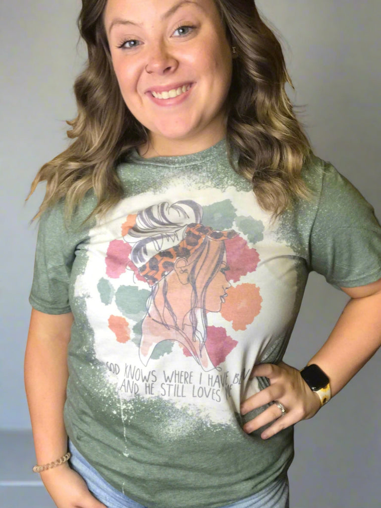 Green short sleeve t shirt with a girl pictured on front. "God knows where I have been and he still love me." written across the bottom.