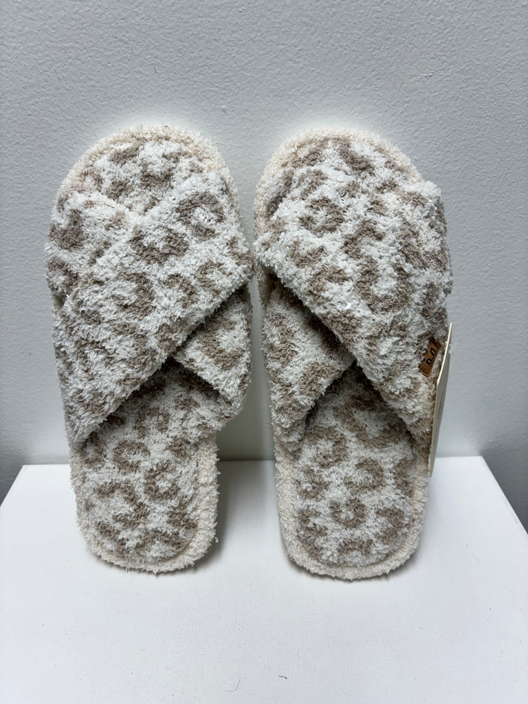 Soft beige and cream leopard print cross band slippers made from plush fabric, displayed on a white background.