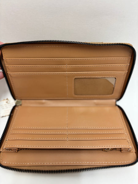 The inside of A neutral beige and tan crossbody wristlet with whipstitch accents and gold-tone hardware, photographed on a clean white background