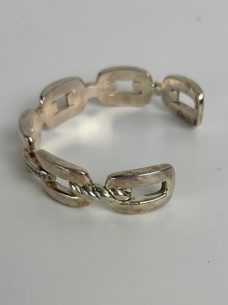 Silver chain-style bracelet on a light gray background