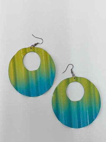 A pair of large circular earrings with an open center, featuring a rippled ombre pattern in shades of yellow, and blue