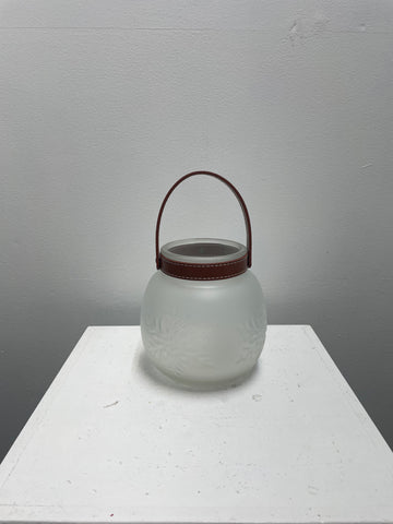 "6x6 inch frosted glass tea light holder with etched snowflake design and brown faux leather carrying strap, perfect for winter and holiday decor"