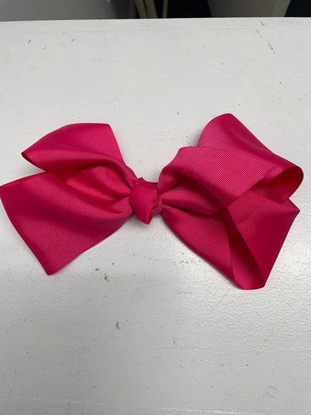 Big hot pink bow on white table.