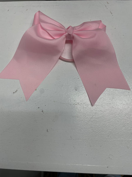 Big baby pink hair tie bow on white table.