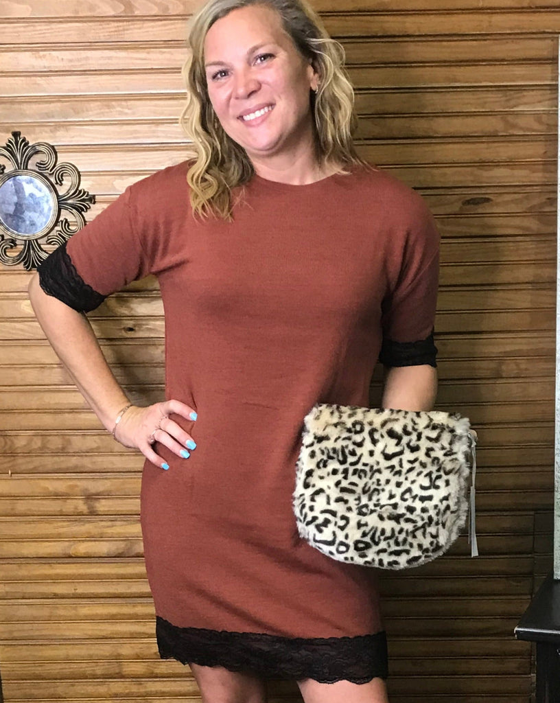 Girl in rust colored lace trimmed dress with fur animal print purse