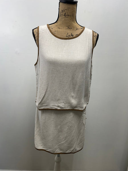Neutral beige two-piece skort set displayed on dress form, featuring sleeveless top and matching skort with elastic waistband