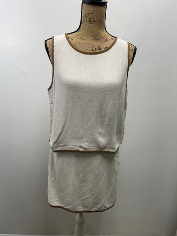 Neutral beige two-piece skort set displayed on dress form, featuring sleeveless top and matching skort with elastic waistband