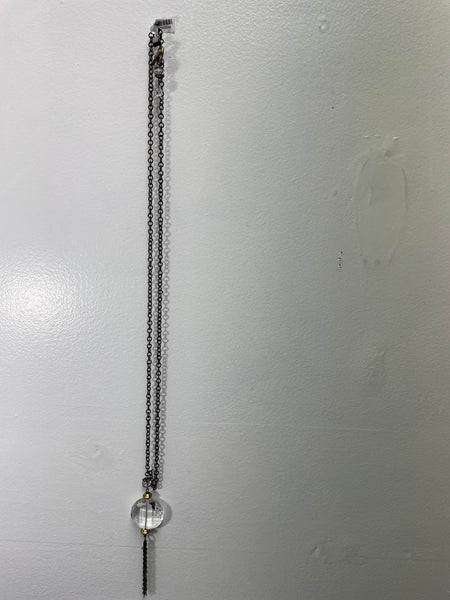Long metal chain with spherical ends on a light gray background