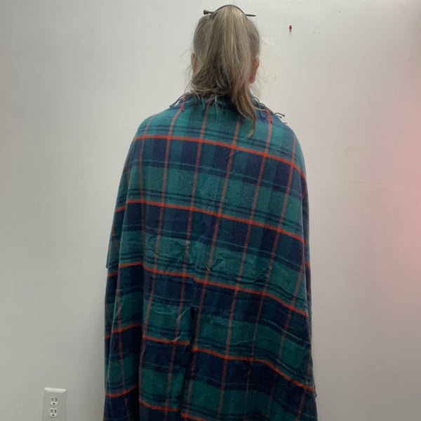 : Plaid ruana with 3-inch fringe tassels. Oversized wrap shawl cape in 100% polyester. Versatile layering piece perfect for fall, winter, and year-round style.