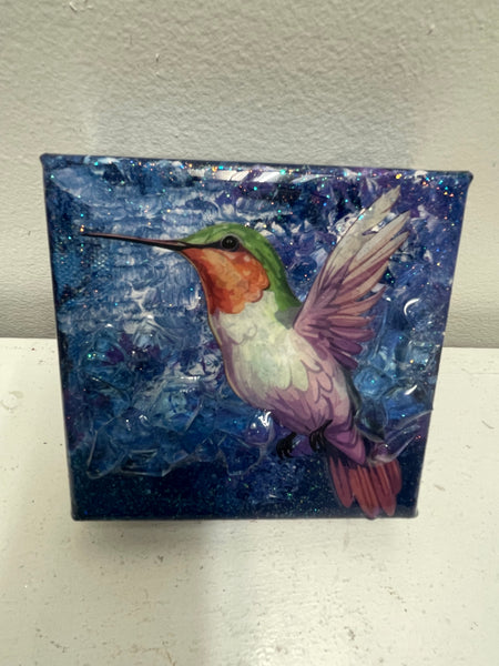 Three-dimensional resin hummingbird mounted on wrapped canvas wall art by Tiffany Sutton featuring detailed wings and natural -blue design