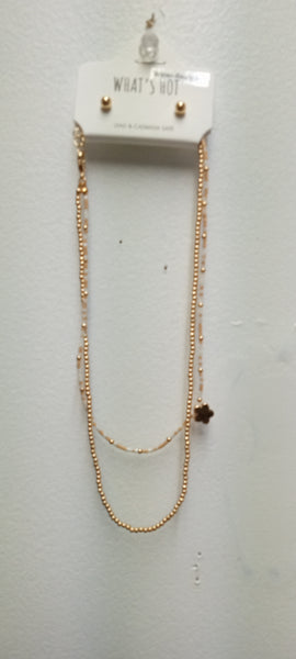 A pair of gold double-layered necklace w/tan/white beads w clover charm/small gold stud earrings 