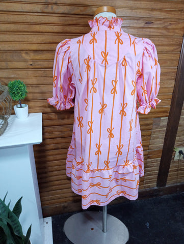 Pink garment with orange patterns on a wooden surface