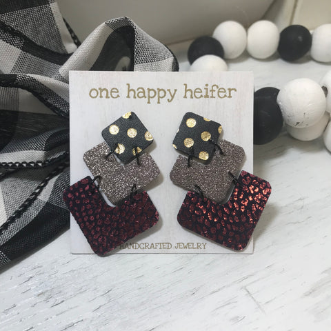 three tiered earrings: red and black on the bottom, brown in the middle and gold and black polka dot top