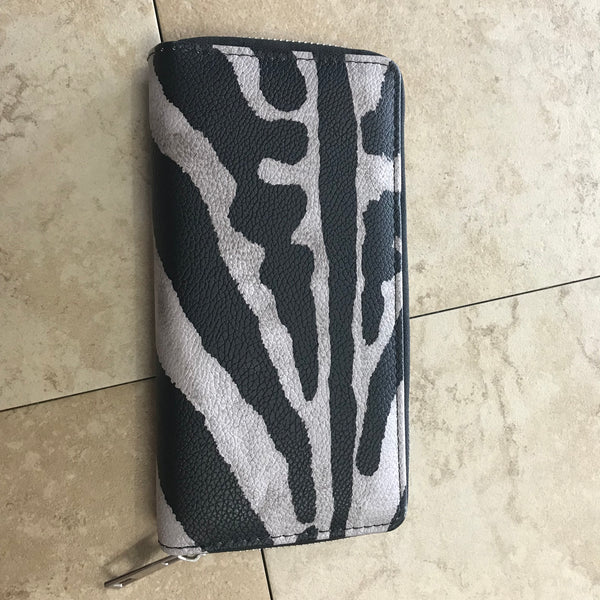 Black and white zebra print wallet with zip closure.