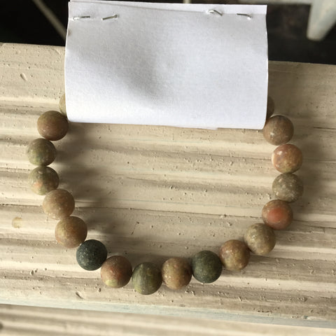 Bracelet: Elastic. Circle earth tone-colored beads. 