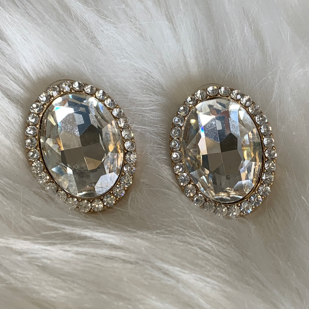 Pierced stud earrings with large oval diamond shaped pendent outlined with a row of small diamond shaped pendents.  