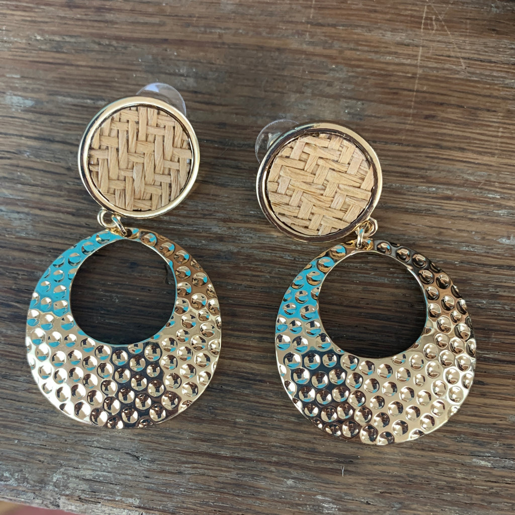 Pierced earrings with a gold outlined with raffia on the inside and a gold hammered hoop circle on the bottom. 