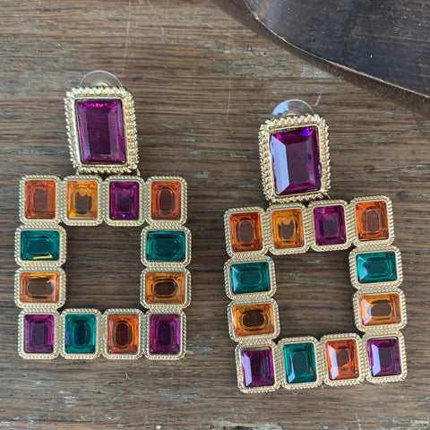 Pierced earrings with a purple rectangle piece outlined in gold at the top and a large hollow square of color rectangle piece (orange/yellow/purple/blue) outlined in gold at the bottom. 