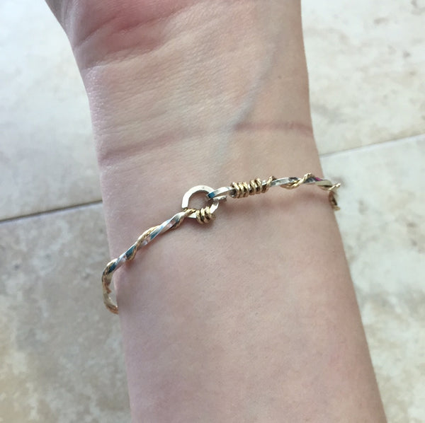 Bracelet:  A sterling silver twisted strand with a 14k gold strand twisted around the silver strand. Hook clasp.