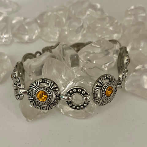 Silver Bracelet with decorative black background. Amber Color Stone in every other piece, Magnetic Closure Bracelet.