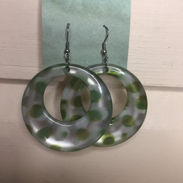 Pierced silver hook earrings: Hoop earrings with silver background and green polka dots.